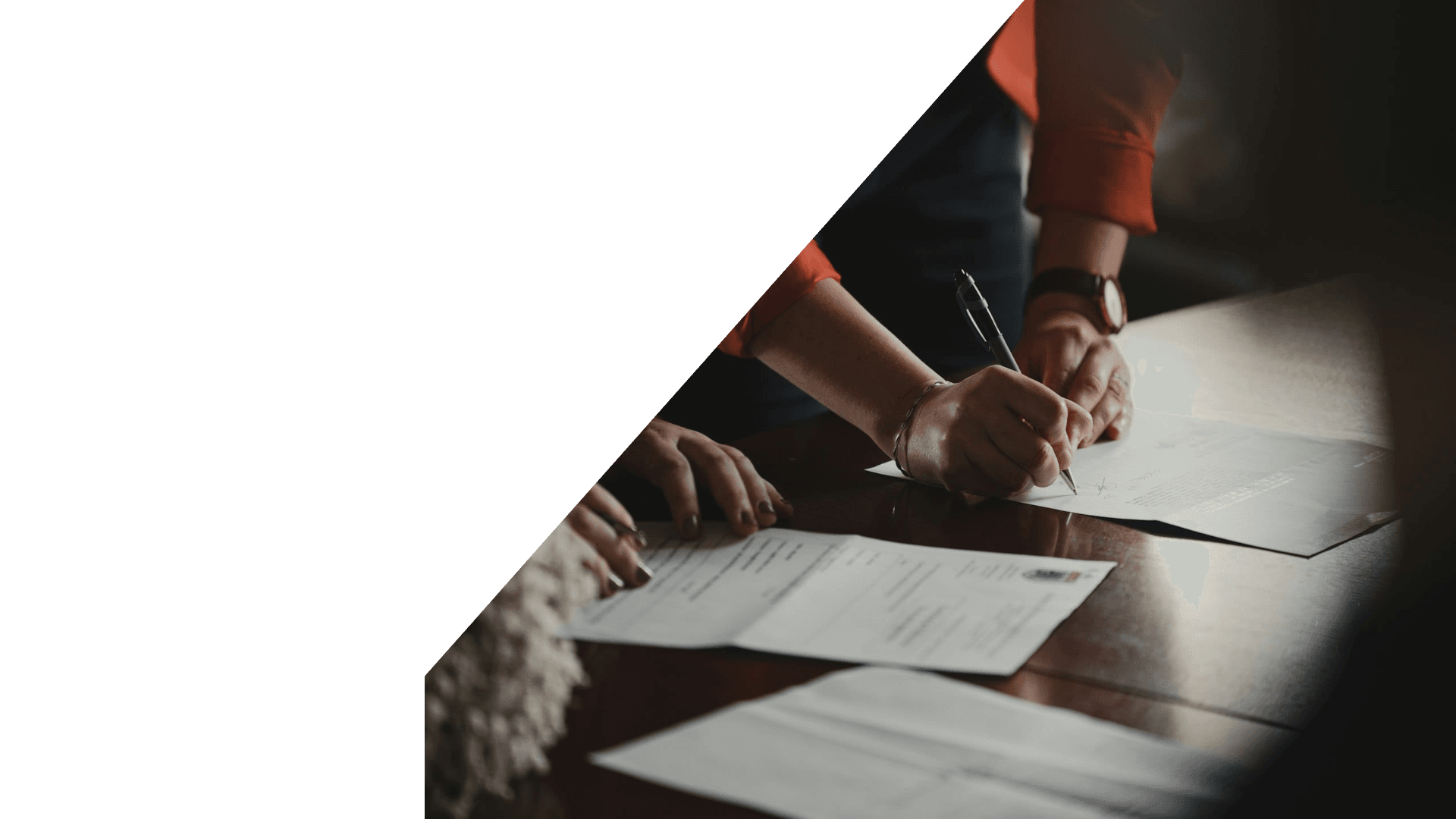 Two people signing company registration documents at a desk